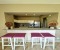 Living-dining room with a bar counter, bar stools, and an open kitchen