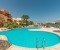 Shared pool with lagoon view, sunbeds and umbrella