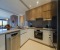 Fully equipped open-plan kitchen with all modern conveniences, including a blender, Dolce Gusto coffee machine, toaster, dishwasher, large refrigerator, and oven.