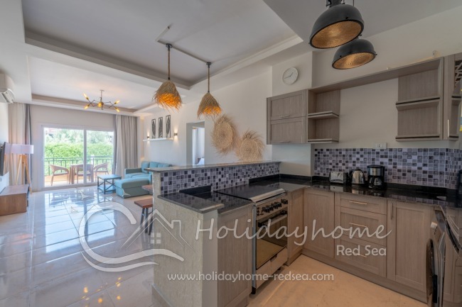 Full equipped kitchen with an adjoining living area , dining table, stove, oven, large fridge with freezer compartment, kettle, toaster, washing machine, 