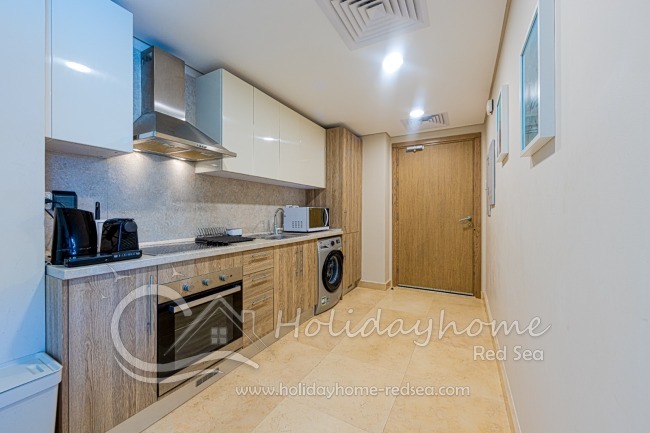 Kitchen with Nespresso maschine, kettle, microwave, cooker and oven.