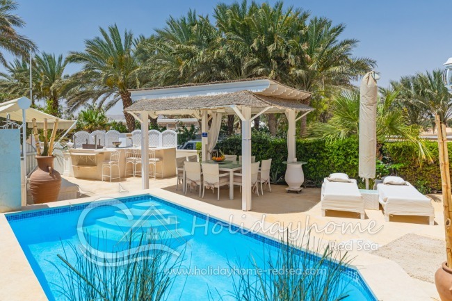 Beautiful terrace with pool, sun beds, dining table, lounge and outdoor kitchen